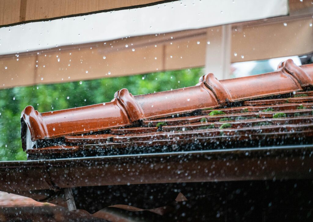 pexels photo 13793186 13793186 Detailed view of rain droplets cascading off a terracotta roof, capturing the essence of a rainy day.